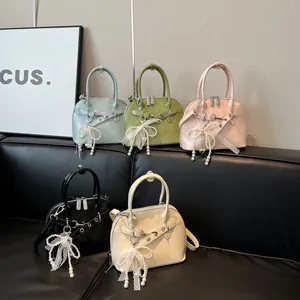 Sac bandoulière coquille à nœud perlé en bleu vert rose noir et blanc faux cuir