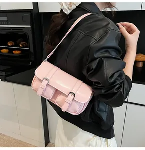 Détail du sac bandoulière rose avec double boucle et finition en cuir brillant
