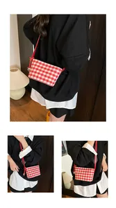 Detailed close-up of red and white checkered canvas tote bag with a gold bell pendant
