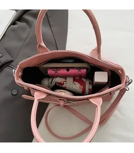 Detailed top view of the spacious pink handbag interior holding a wallet and essentials