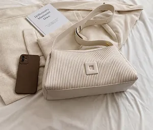 Vista dettagliata della borsa a cuscino plissettata bianco off-white con fibbia quadrata