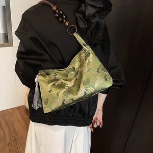 Elegant green silk shoulder bag with crane patterns and wooden bead strap