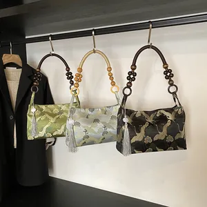 Three colors of Chinese style embroidered handbags with pine tree patterns and bead handles