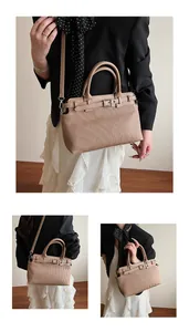 Detail showing elegant vertical pleated texture and metal buckle on beige leather handbag