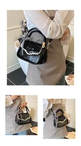 Detail of black crossbody bag with white lace trim, bow, and checkered ribbon on the handle