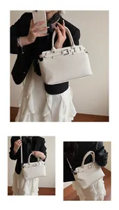 Detail of cream pleated tote bag featuring leather strap buckle and detachable shoulder strap