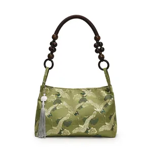 Green silk handbag with crane and cloud patterns featuring unique wood bead handles