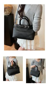 Detailed view of black pleated handbag with silver hardware and adjustable shoulder strap