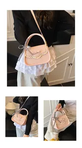 Close-up of pink leather crossbody bag featuring lace edges, bows, and a plaid silk ribbon