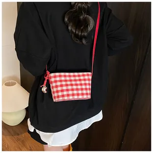 Detail of red and white checkered canvas tote bag with moon charm decoration