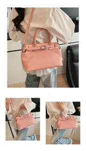 Detail of pink pleated handbag with decorative buckle strap and silver hardware