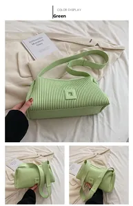 Dettaglio borsa a cuscino plissettata verde chiaro con tracolla e patch logo quadrato