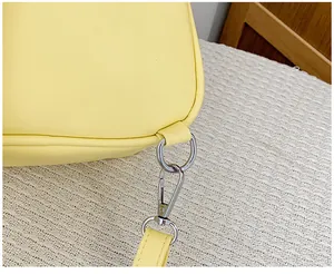 Macro detail of pale yellow PU leather bag featuring silver metal rings and lobster clasp