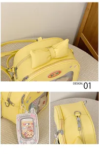 Detail view of the yellow ita bag with bow, transparent window, and cartoon rabbit charm