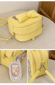 Detail view of the yellow ita bag with bow, transparent window, and cartoon rabbit charm