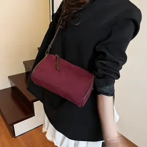 Retro burgundy cylindrical crossbody bag in matte suede with slim brown strap