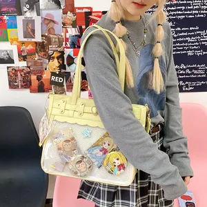 Pale yellow Ita bag with clear PVC window and heart charms in a trendy street setting