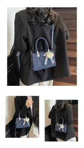 Detail of blue snakeskin crossbody bag with woven handle and pearl bow charm