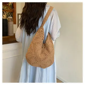 Detail van de handgehaakte hobo-tas in camel met ingewikkelde opengewerkte bloempatronen