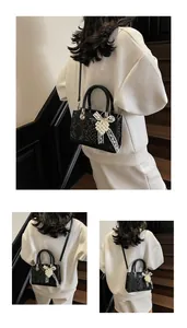Detail of black snake texture bag featuring elegant white pearls and a lace bow charm