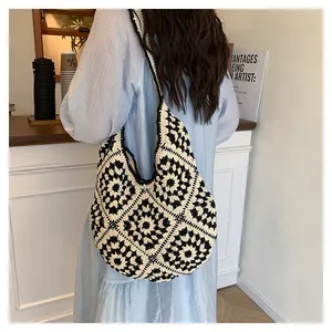 Achteraanzicht van een model met de zwart-witte gehaakte hobo-tas in een café