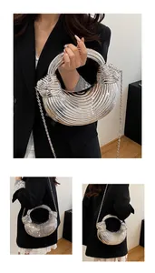 Macro detail of silver crescent evening bag with 3D wave texture and metal chain