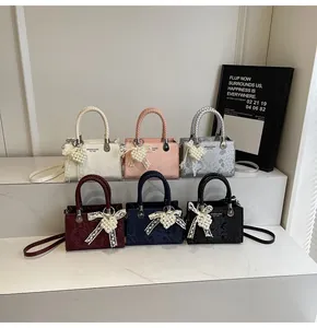 Detailed display of six color variants of snake embossed handbags with braided handles