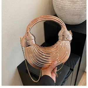 Close-up of rose gold crescent metal handbag featuring pleated texture and ring handle