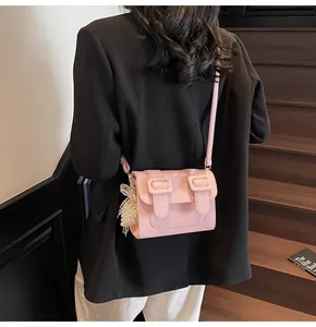 Detailed back view of model wearing a pink satchel with lychee grain and pearl charm