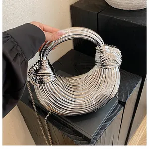 Detail showing the silver metallic handbag with unique pleated texture and circular handle