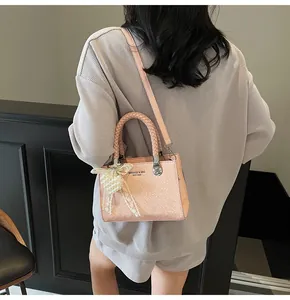 Pink croc-embossed handbag featuring elegant lace bow and pearl charm decoration
