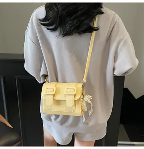 Back view of model wearing a yellow satchel with pearl charms and lace bow detailing