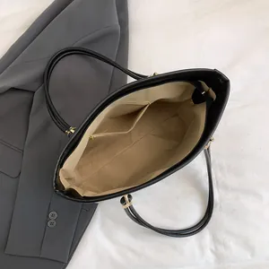 Large black leather tote bag with gold hardware and interior pockets for daily commute