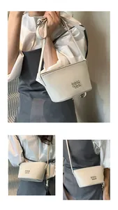 Vue détaillée du sac seau en cuir grainé blanc cassé avec logo en métal et bandoulière