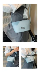 Détail d'un sac à bandoulière en cuir bleu clair à motif litchi et lettrage métallique