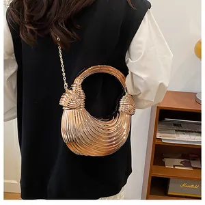 Detail of a golden sculptural handbag featuring a metallic finish and chic chain strap
