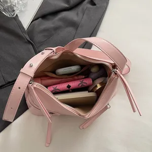 Borsa a spalla rosa minimalista a forma di dumpling con tracolla larga e nappa