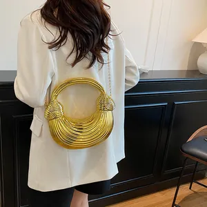 Futuristic golden half-moon metal handbag with wave texture and round handle