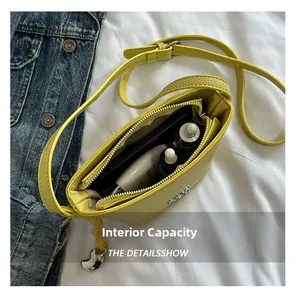 Vue de dessus de l'intérieur du sac jaune montrant le rangement pour téléphone et produits