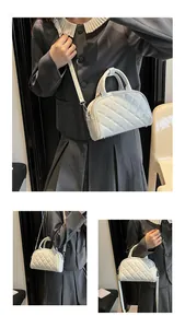 Detail of white quilted Boston bag with silver hardware and adjustable shoulder strap