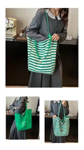 Detail view of large green striped canvas tote bag with Beau merci print for women