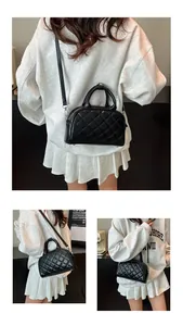 Detail view of black quilted Boston bag with silver hardware and detachable strap