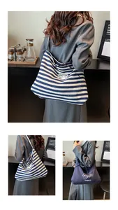 Detail of striped canvas tote bag and navy shoulder bag with artistic text embroidery