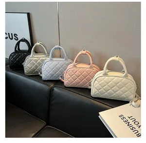 Collection of quilted Boston bags in five colors on a black leather sofa with props