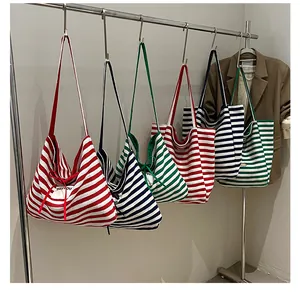 Hanging display of large striped canvas tote bags in red, navy blue, and green