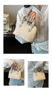 Detail of beige woven shell bag with leather handles and detachable shoulder strap