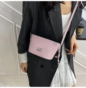 Détail du sac à bandoulière en cuir grainé rose avec logo en métal et nœud décoratif