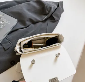 Internal view of the white leather crossbody bag showing ample capacity and zip pocket