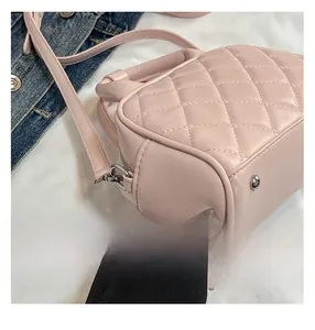 Detailed close-up of pink quilted leather bag featuring silver protective metal feet