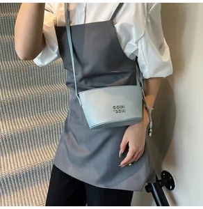 Gros plan d'un mini sac seau bleu clair avec texture cuir grainé et logo métallique